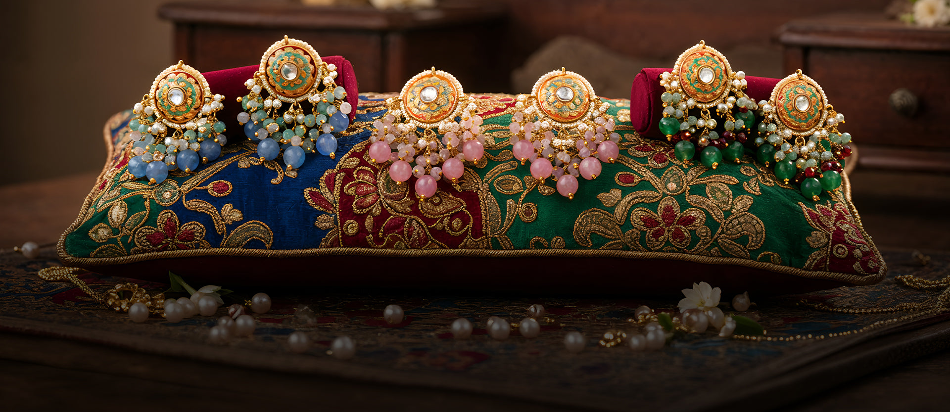 Set of ornate earrings on a decorative cushion with a blurred background